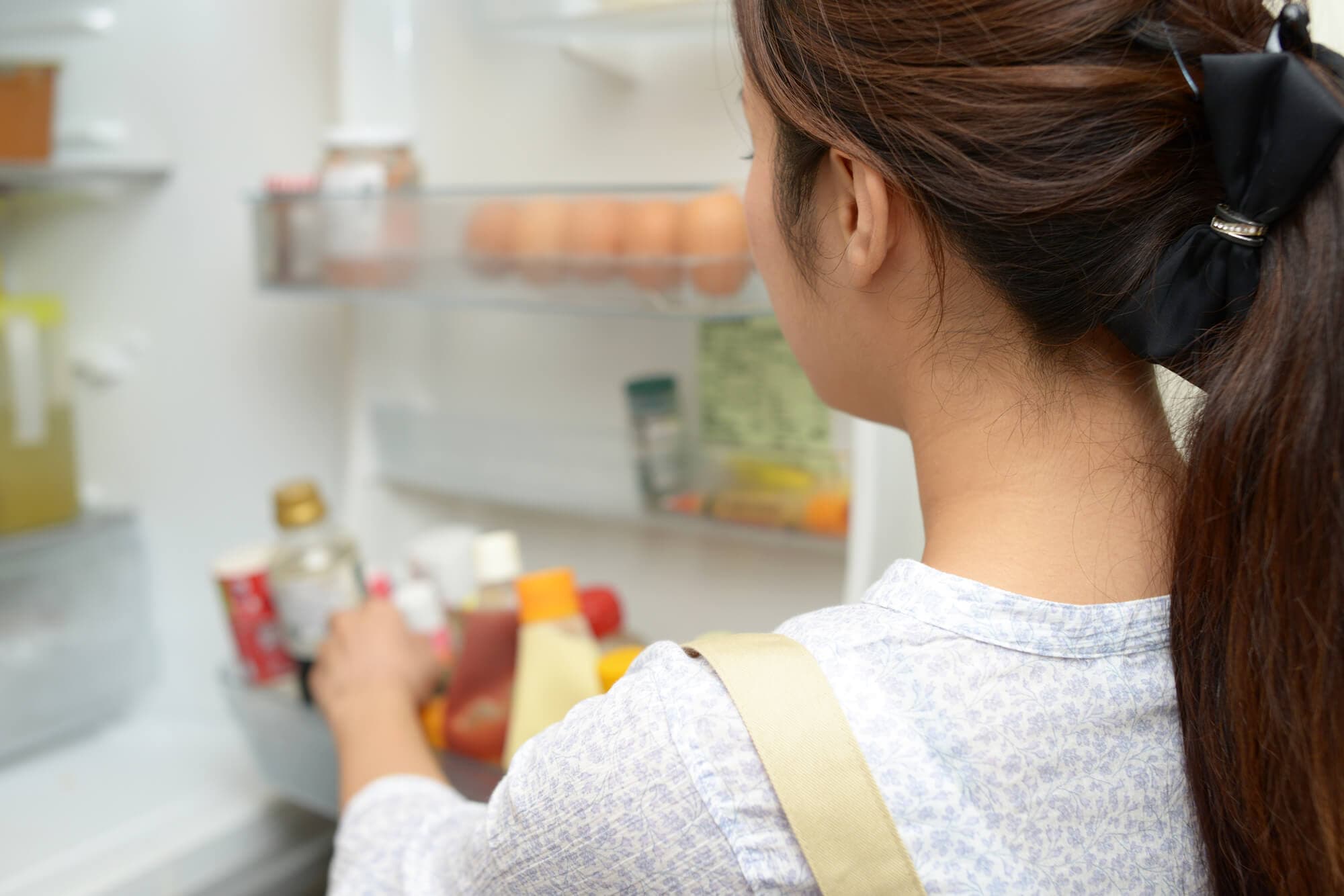 冷蔵庫の中身を取り出す女性
